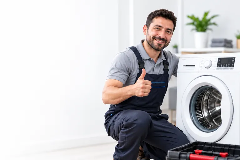 Çamaşır makinesinin yanında çalışan servis teknisyeni